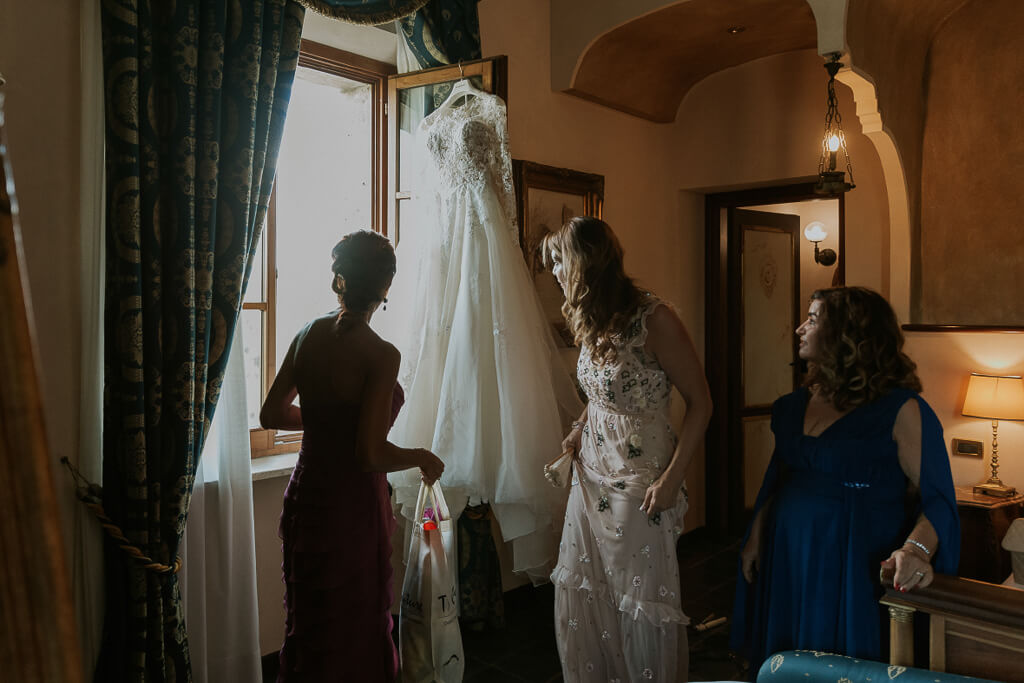 le testimoni osservano il vestito della sposa