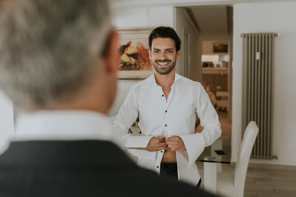 lo sposo si abbottona la camicia