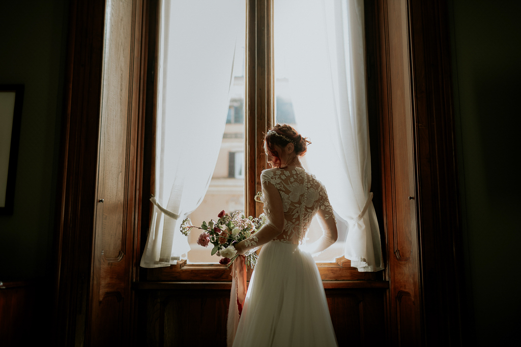 la sposa col vestito bianco davanti alla finestra