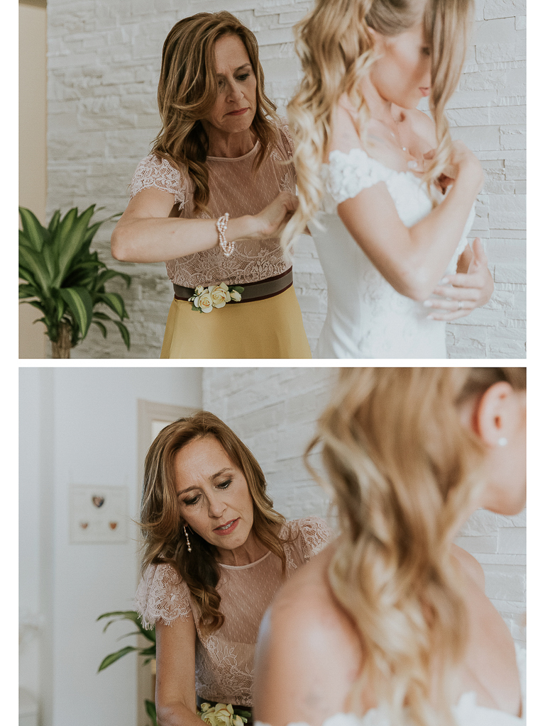 la mamma chiude il vestito della sposa