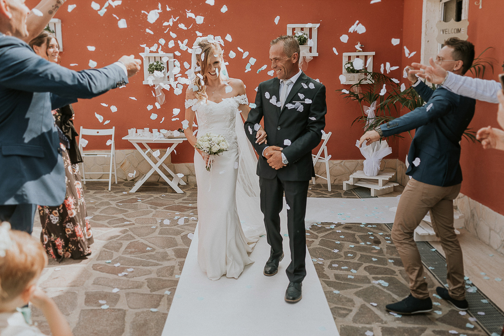 la sposa esce di casa con petali