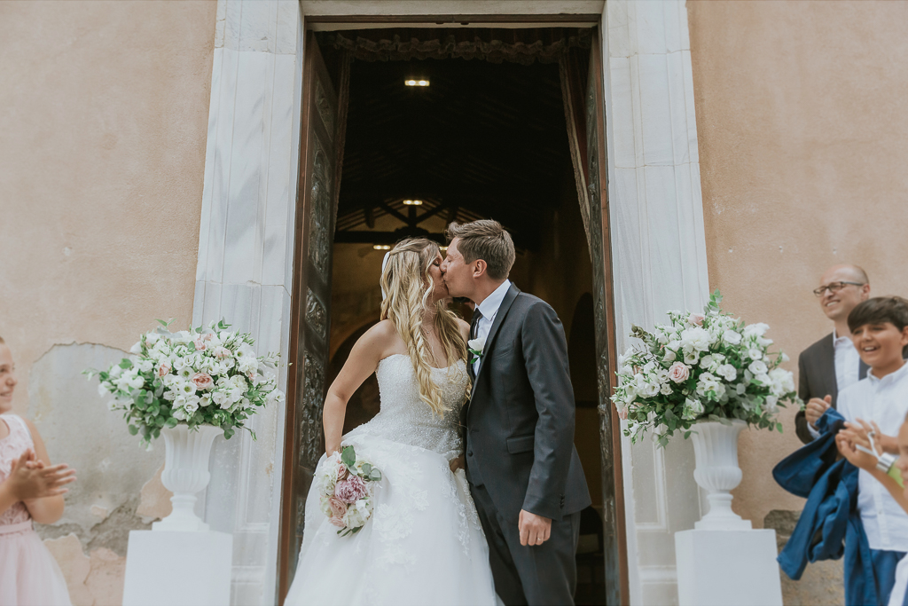 sposi si baciano dopo il lancio del riso