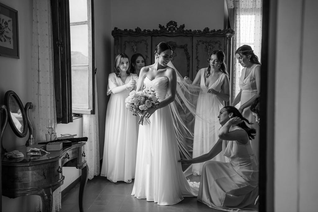 le damigelle sistemano il vestito della sposa