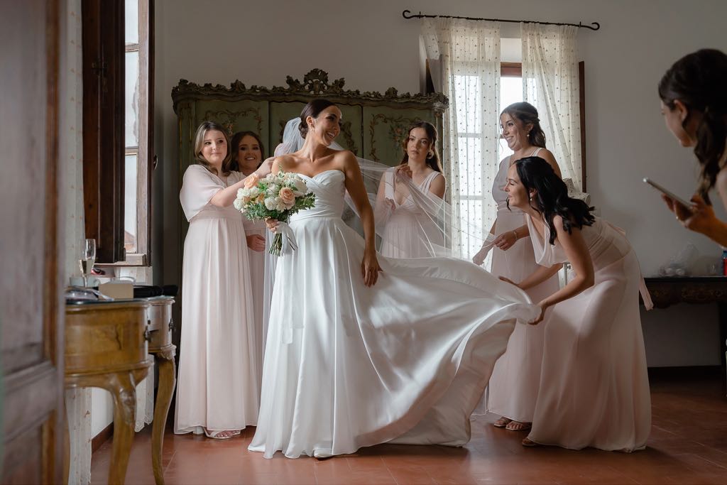 le damigelle sistemano il vestito della sposa